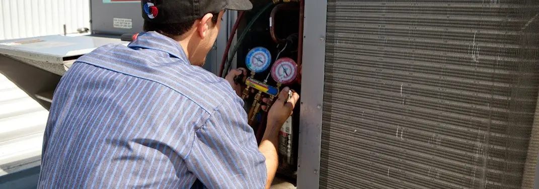 HVAC technician servicing a condenser unit in Winterville